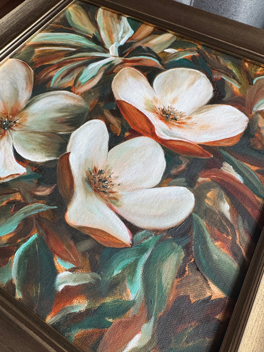 Framed artwork of white flowers with green leaves